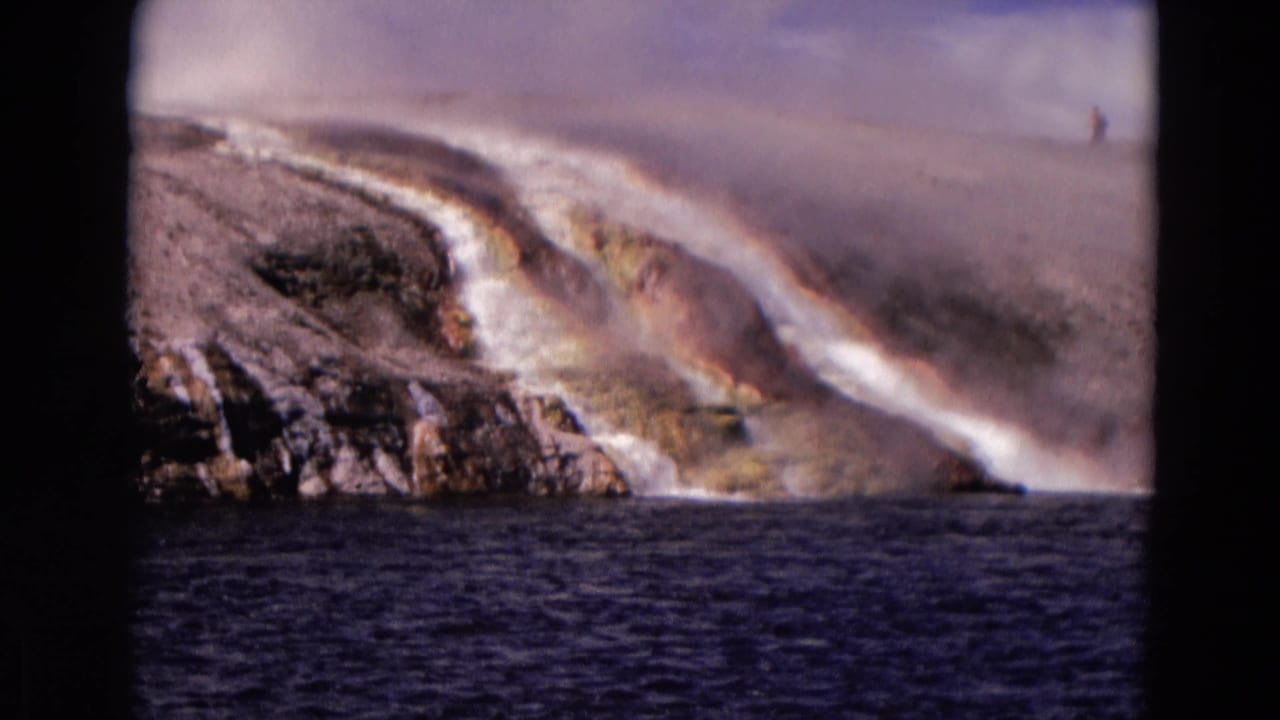 1967 Yellowstone view of fast water, mist, pale banks, and a small distant person on the upper right of the landscape.