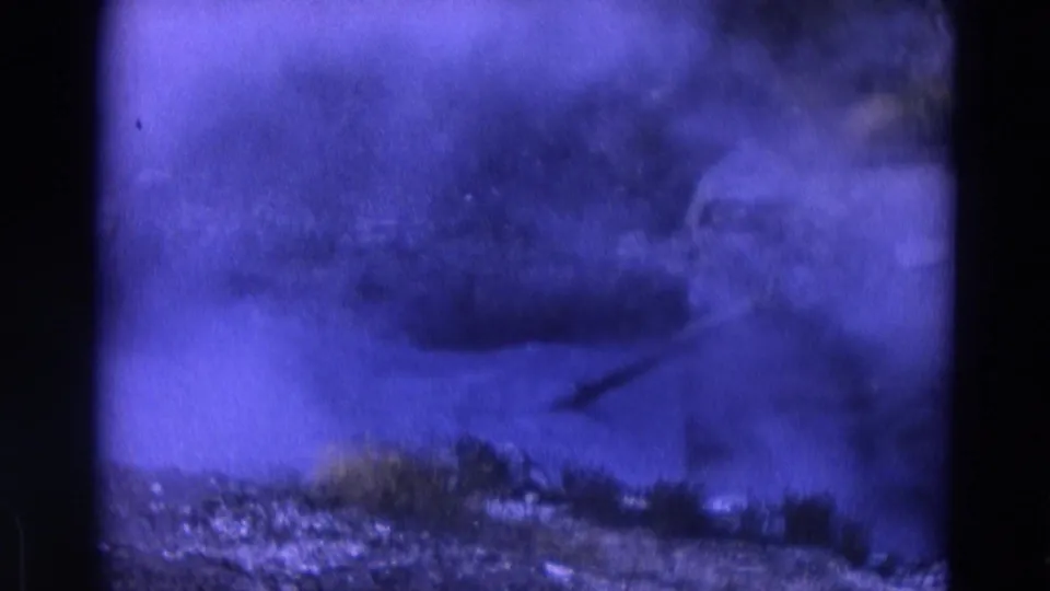 1967 Yellowstone 8mm frame showing smoke or steam drifting over rocky terrain with sparse vegetation and a purple color cast.