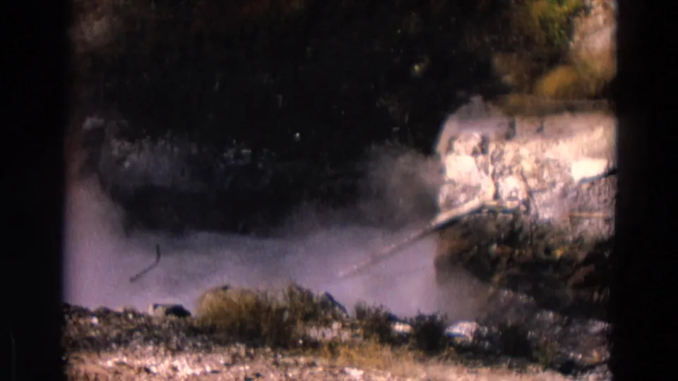 1967 Yellowstone 8mm frame showing a low steam cloud over wet-looking rocks, brush, and a diagonal pipe or branch-like object.