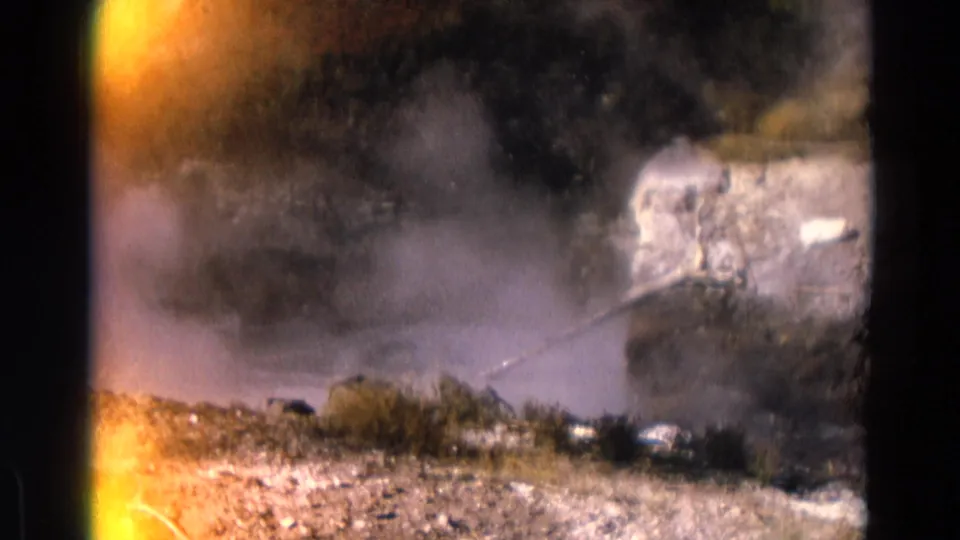 1967 Yellowstone 8mm frame showing geyser steam drifting over rocky terrain with shrubs and exposed film edges.