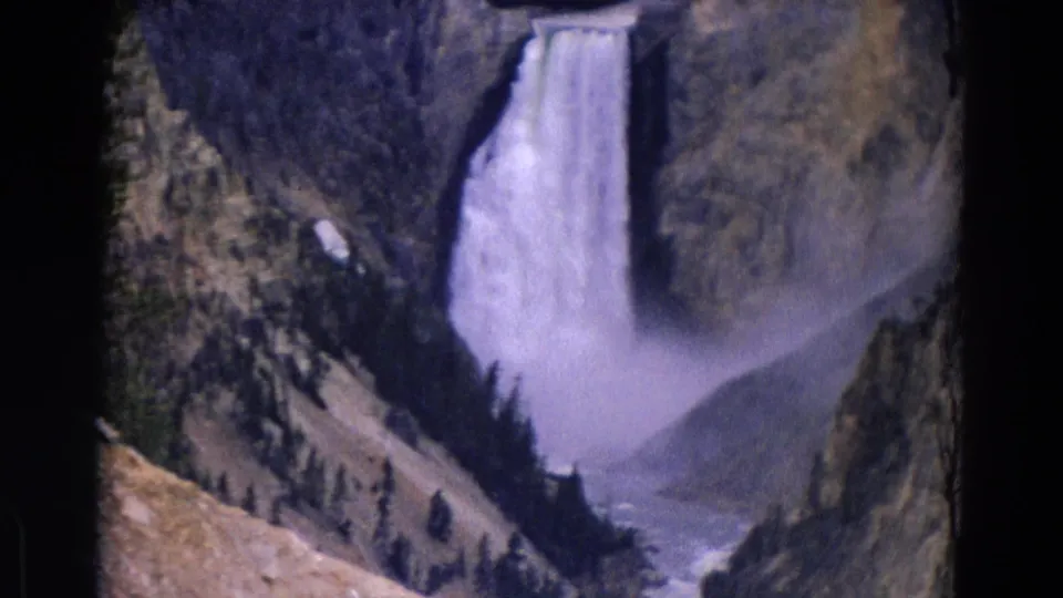 Yellowstone waterfall footage from 1967 showing cascading water, canyon mist, evergreens, and the river channel below.