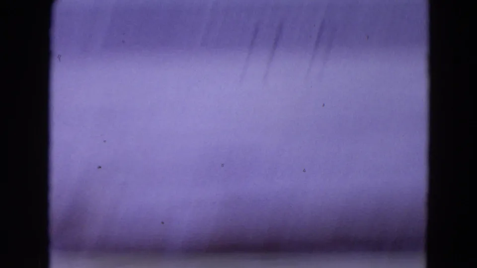 A soft, purple-gray 8mm transition frame from the Yellowstone winter clip, with dark borders and visible film texture.