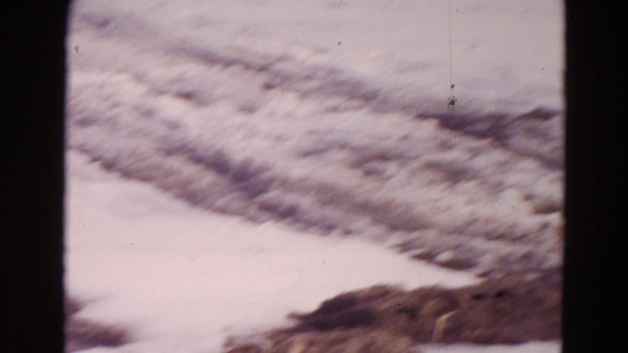 1967 Wyoming frame showing a snowy frozen shoreline and ice surface, with no people visible.