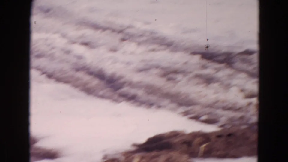 1967 Wyoming frame showing a snowy frozen shoreline and ice surface, with no people visible.
