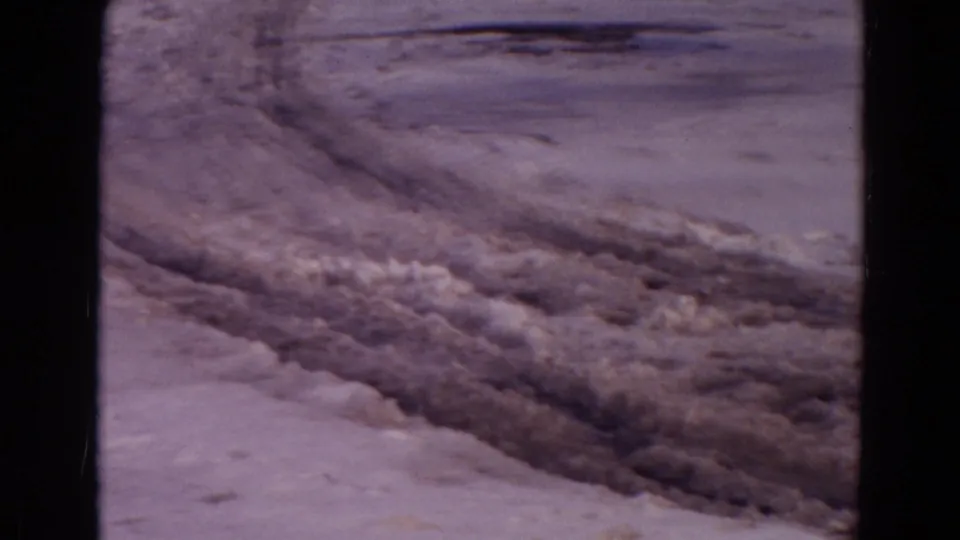 1967 Yellowstone 8mm frame showing a rough dirt road with tire tracks cut through snow-dusted terrain.