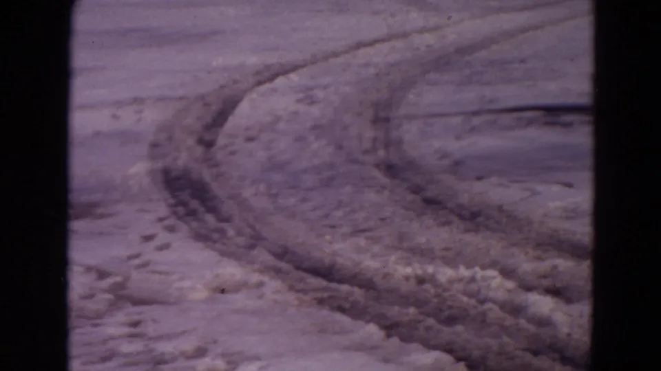 8mm Yellowstone frame from 1967 showing a curved rutted track across snow-dusted ground.