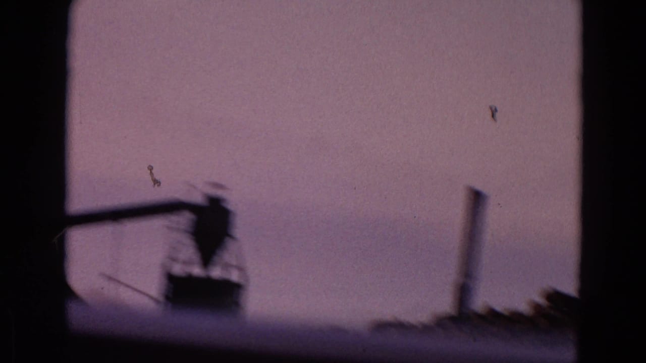 Dark window frame with a distant silhouetted industrial structure against a purple sky.