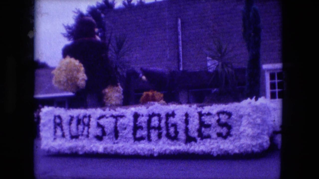 1976 Fort Wayne parade float reading Roast Eagles, with a standing participant and yellow pom-poms behind the floral front.