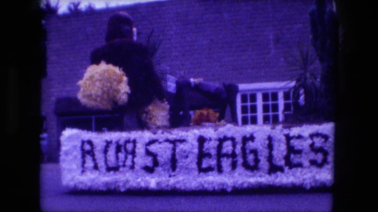 Fort Wayne parade frame showing the Roast Eagles lettering across a white float, with a dark-clothed person standing behind it.