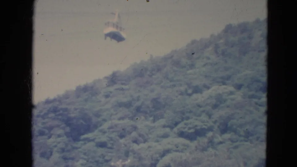 Soft 8mm frame from Minnesota in 1976 showing the gondola above the forest canopy as the hillside fills most of the view.