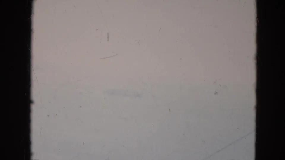 End frame from the Minnesota 8mm clip with the cable car nearly out of view, leaving pale sky and film wear visible.