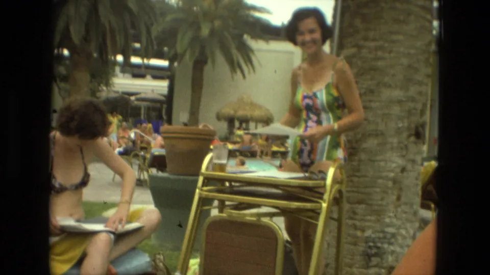 At the Las Vegas resort, one woman sits with papers while another stands near the metal table and lounge area.
