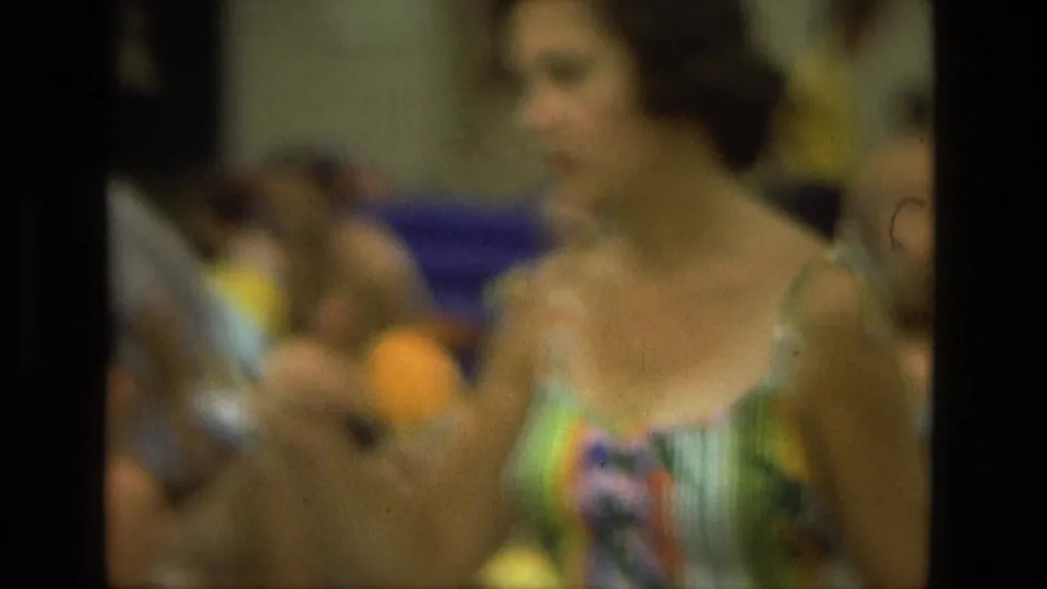Soft 8mm close view of a woman in a colorful dress at a 1978 Las Vegas poolside gathering.