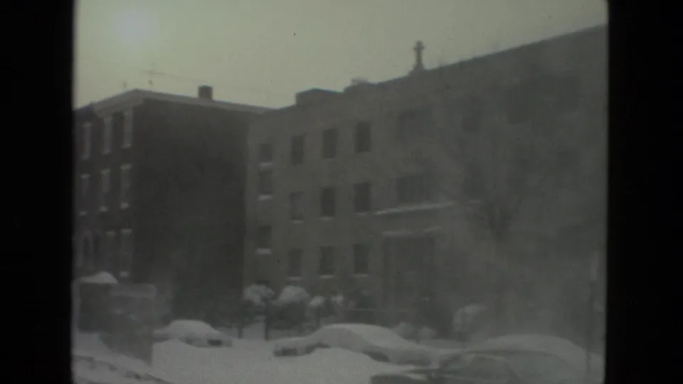 Brick multi-story residential buildings line a snow-covered Drexel Hill street in 1978, with parked cars and sidewalks heavily blanketed by snow.