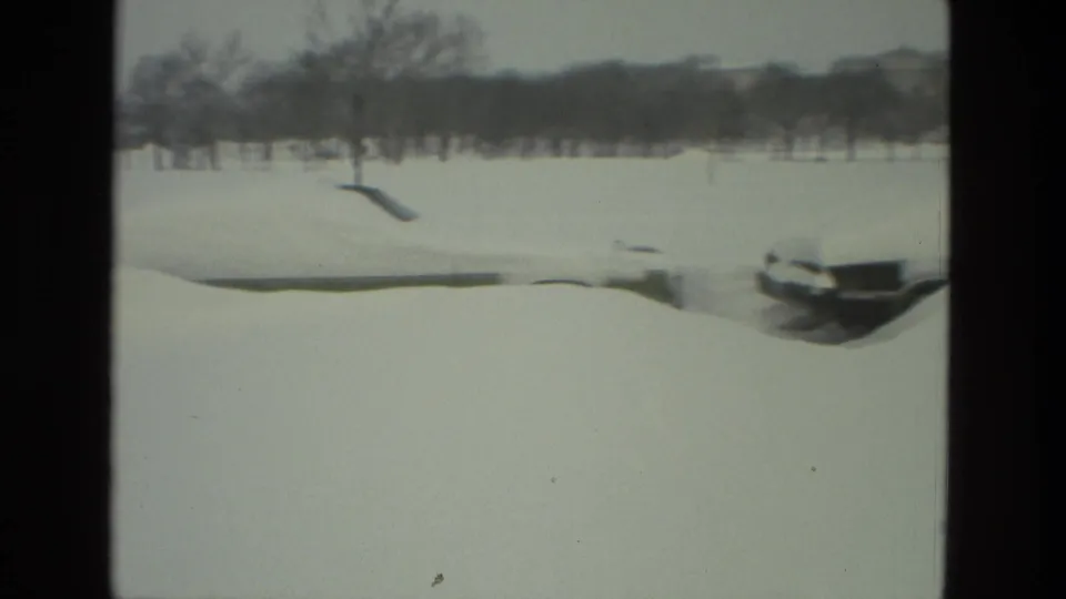 1978 Drexel Hill 8mm frame showing a snow-covered residential open area with bare trees and partially buried cars.