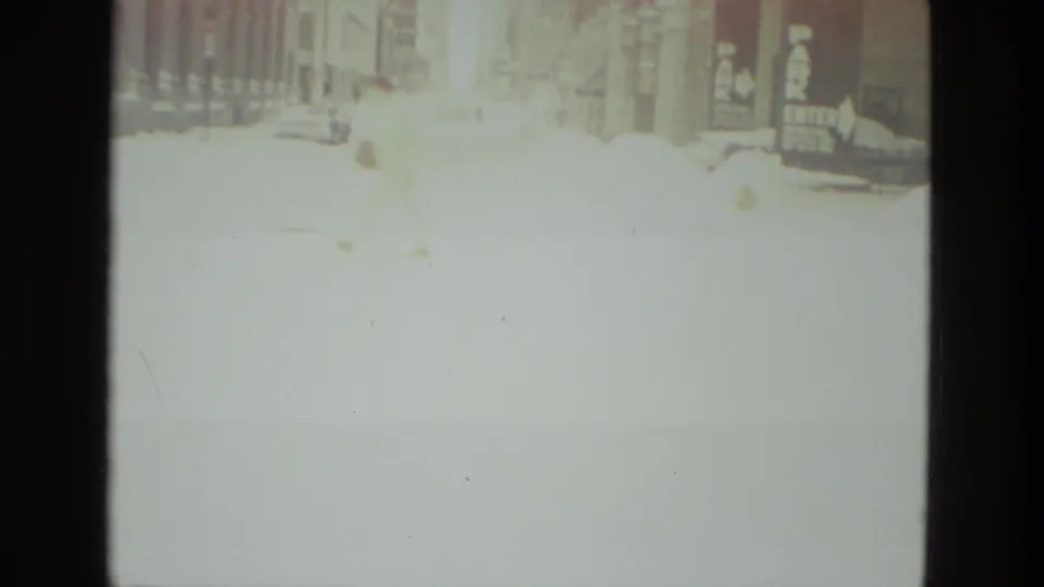 Soft, overexposed 1978 street view in Drexel Hill with deep snow, vehicles, and building fronts along the road.