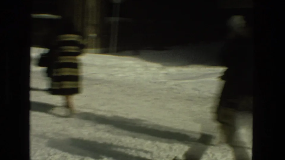 A blurred 8mm frame shows pedestrians in winter coats crossing a snow-covered urban street in the Drexel Hill clip.