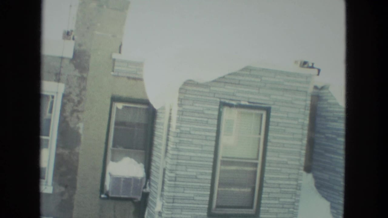 Drexel Hill residential houses in snow, seen through a dark window frame in 1978 8mm home-movie footage.