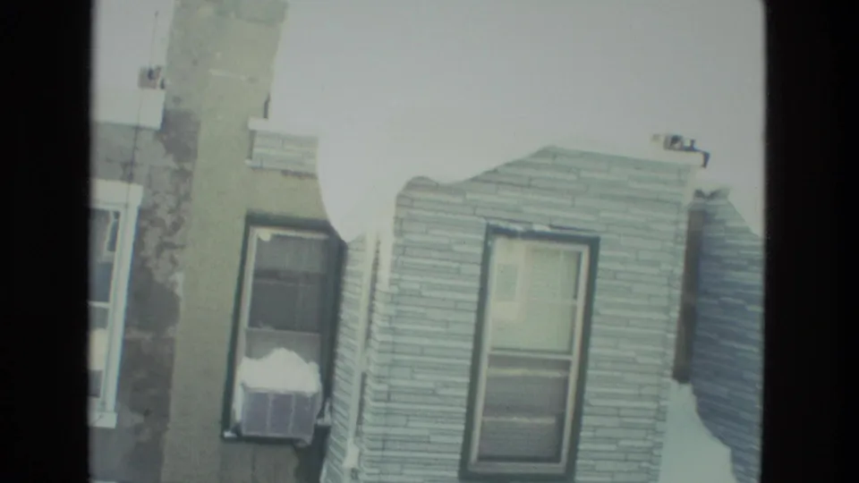 Drexel Hill residential houses in snow, seen through a dark window frame in 1978 8mm home-movie footage.