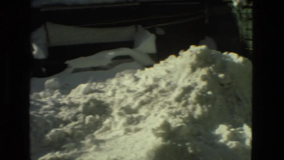 Deep snow piled below residential exterior walls and windows in Drexel Hill, Pennsylvania, from the supplied 1978 8mm clip.