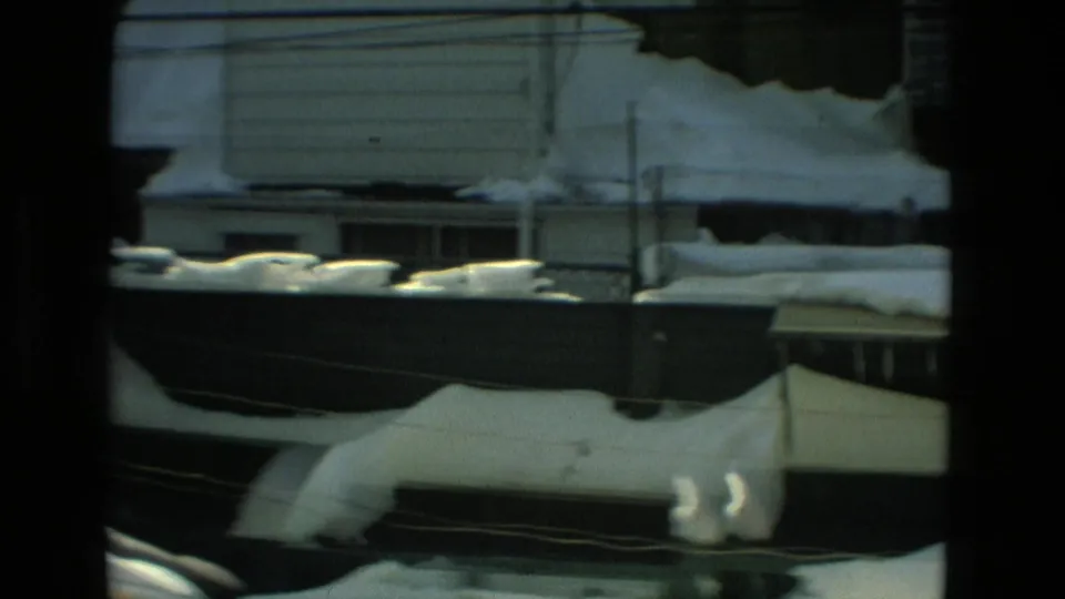 Drexel Hill residential exterior with thick snow on porch rooflines, railing areas, and overhead wires in a 1978 home movie.