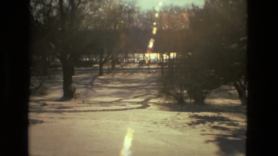 A snow-covered Drexel Hill park landscape appears in low winter sunlight, with bare trees and long shadows in 1978 home-movie footage.