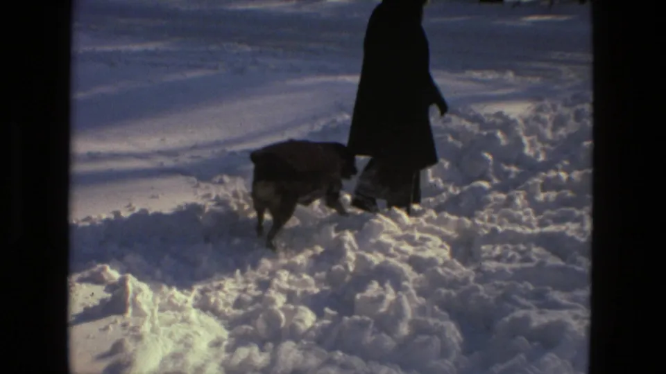 In 1978 Drexel Hill home-movie footage, a dark-coated person walks through deep snow while a dog moves alongside.