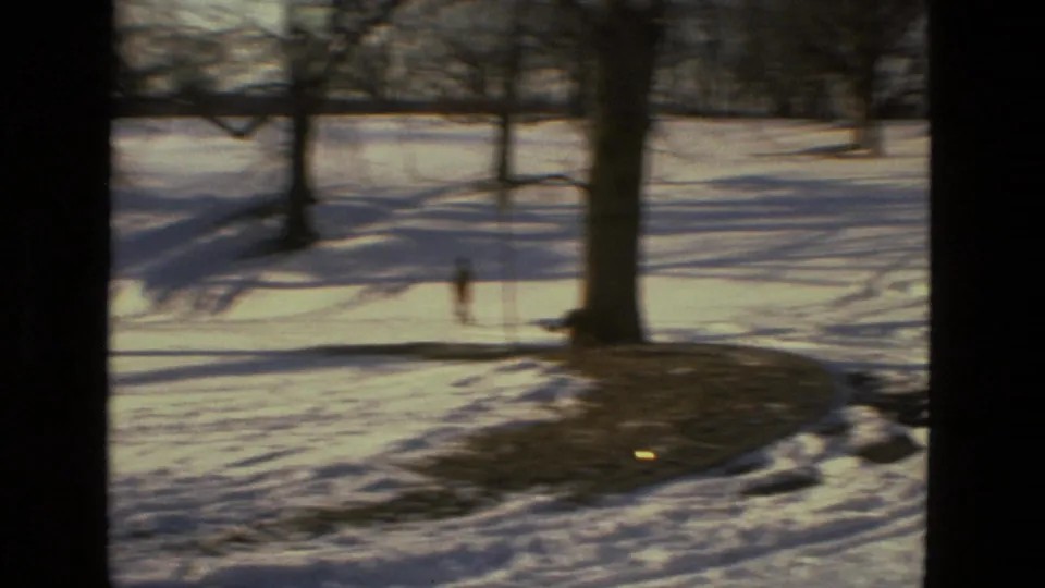 1978 Drexel Hill park view through dark framing, showing snow, bare trees, and long shadows across the ground.
