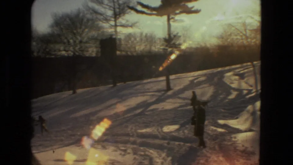 A warm-flared 1978 Drexel Hill frame shows a bundled figure on a snowy park slope with bare trees and long winter shadows.