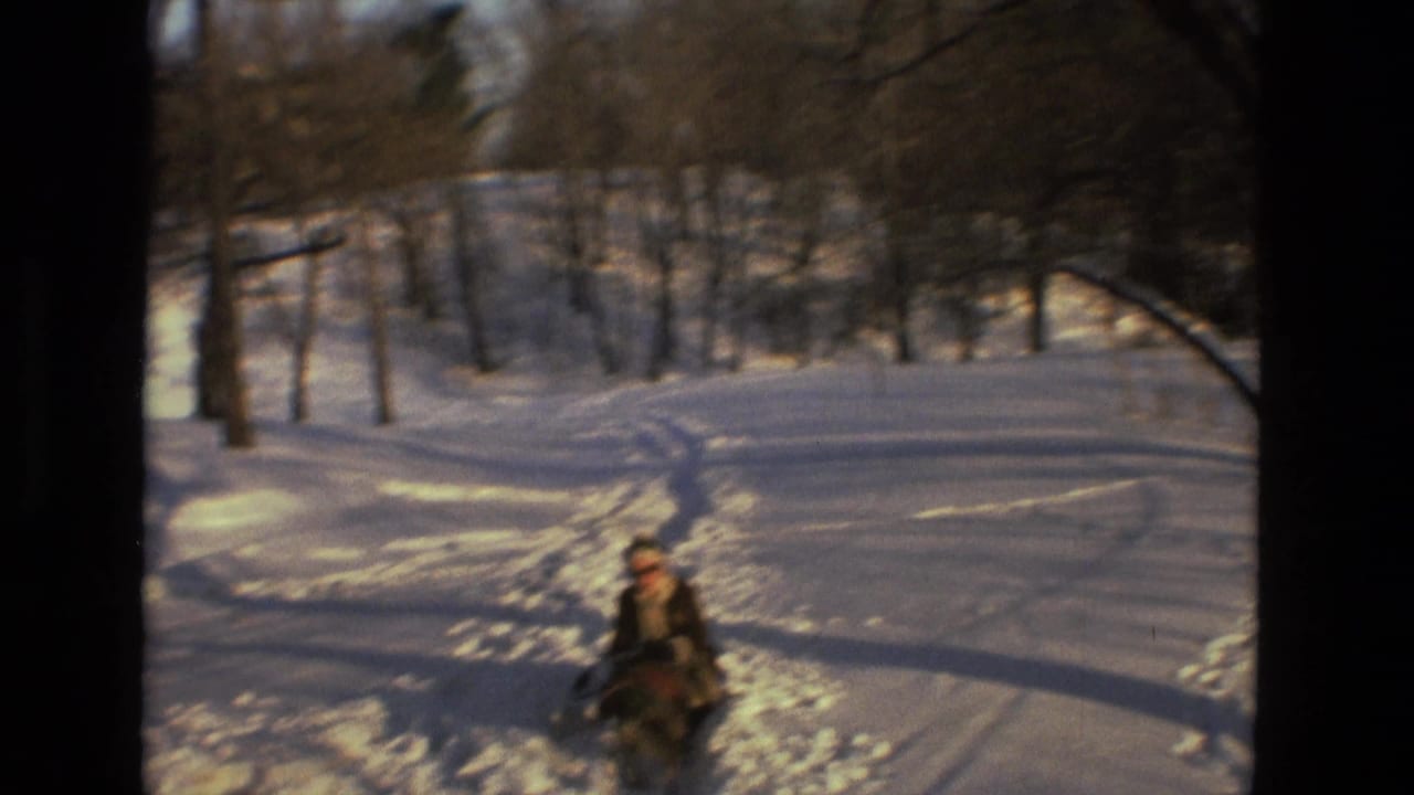 Sledder approaches the camera on a tracked snowy path.