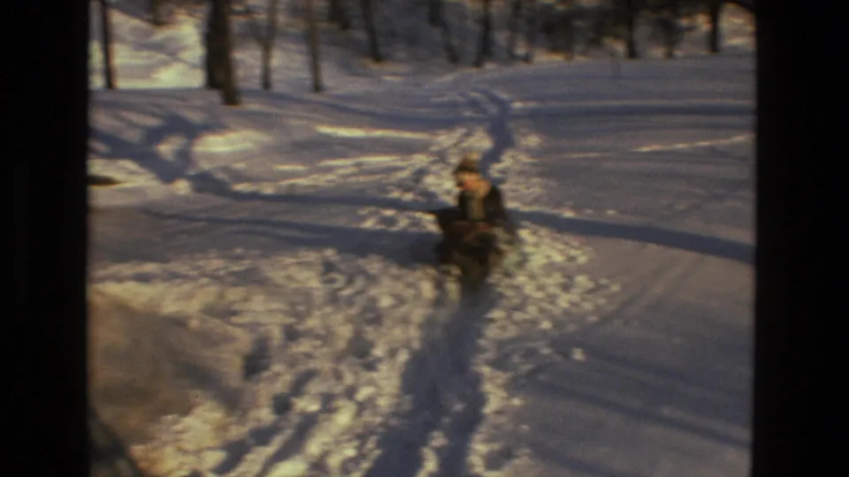 A child in winter clothing appears in deep snow in wooded Drexel Hill, Pennsylvania home-movie footage from 1978.