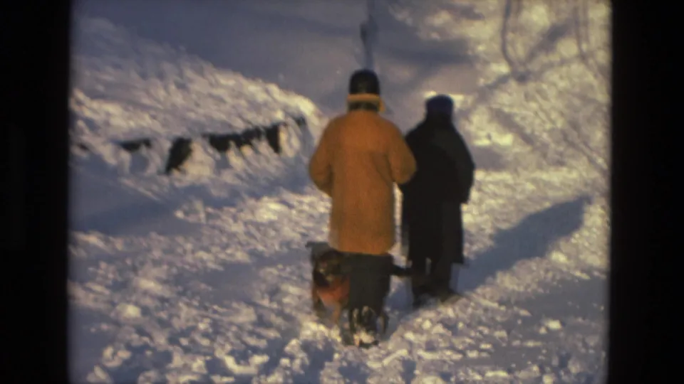 Three bundled people and a small dog move along a snow-covered path in this 1978 Drexel Hill home-movie frame.