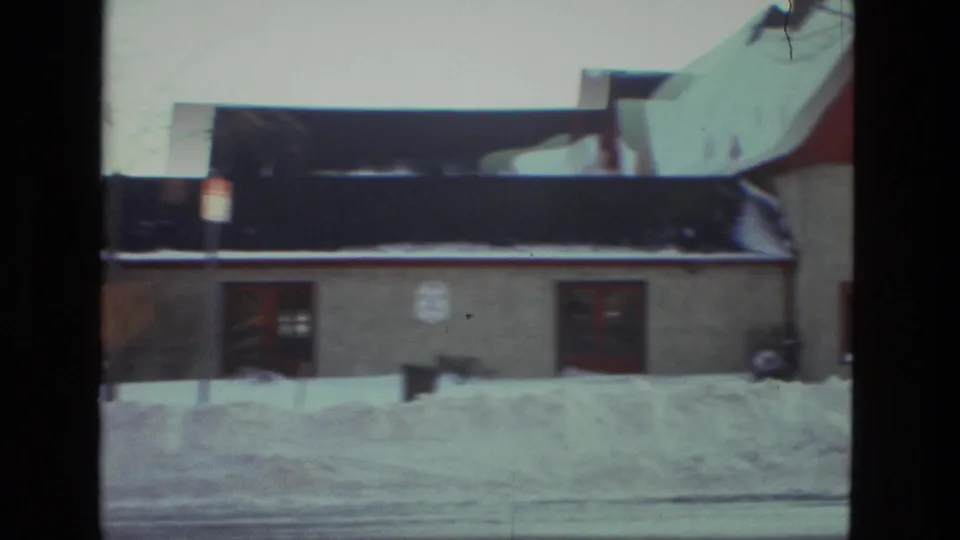 1978 Drexel Hill footage shows a low residential or small neighborhood building behind a high roadside snowbank.