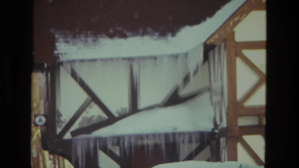 1978 Drexel Hill close view of long icicles hanging from the roofline of a snow-covered residential exterior.