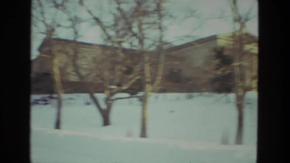 Drexel Hill 1978 frame of snow-covered grounds, leafless trees, and a low building beyond the park area.