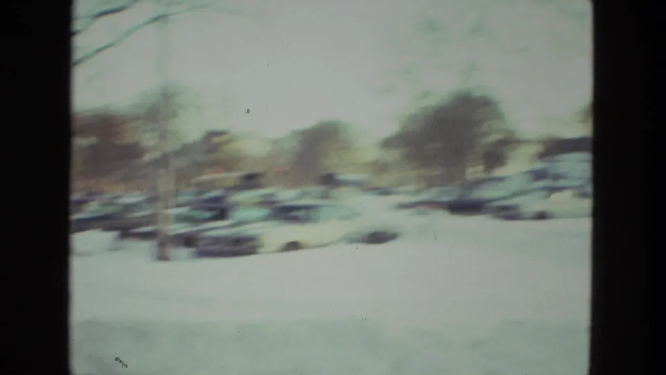 Snow blankets a Drexel Hill street in 1978, with parked cars and bare trees softened by handheld 8mm focus.