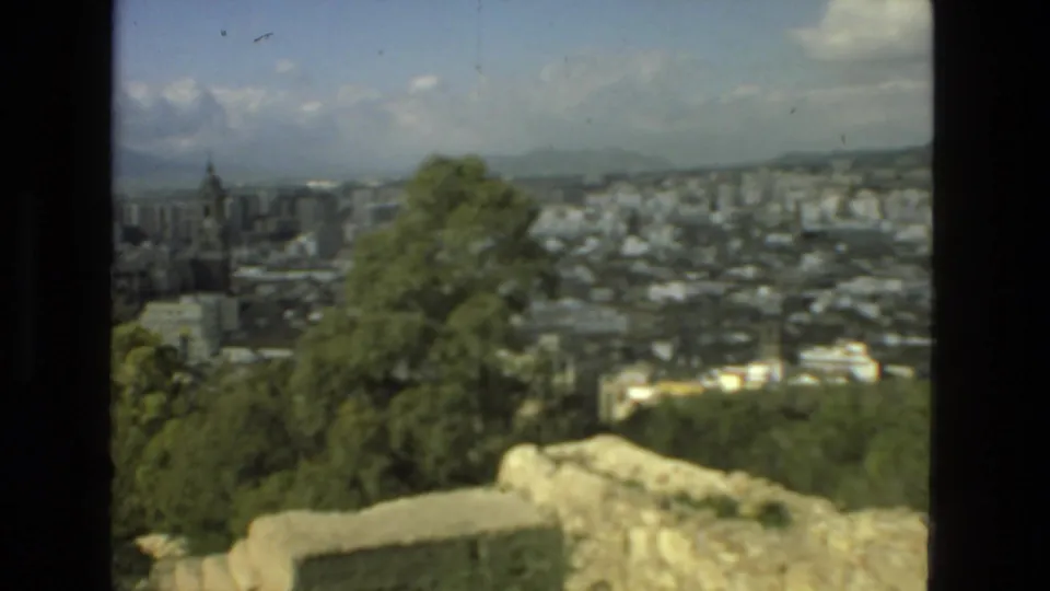 Elevated 1978 8mm town panorama in Drexel Hill with foreground trees, low buildings, distant hills, and a tower-like structure at left.