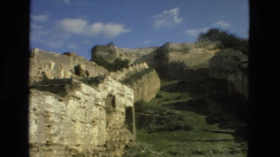 Granada, Spain ruins seen in 1978 home-movie footage, with broken stone walls, grassy ground, and blue sky.