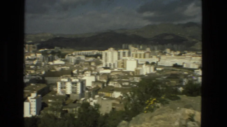 Granada, Spain, 1978 Super 8 panorama showing apartment blocks below dark hills and a cloudy sky.