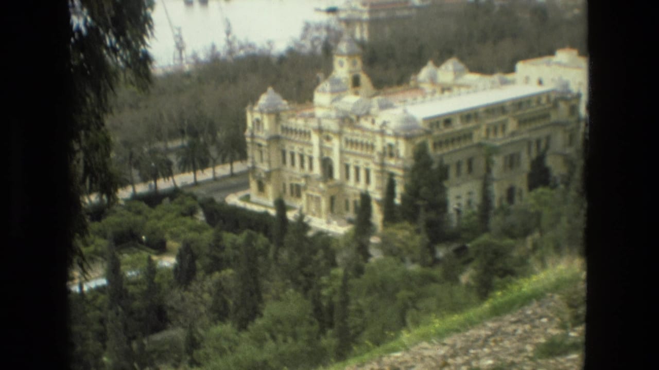 1978 8mm view in Granada showing a large ornate palace above dense gardens and a wooded hillside.