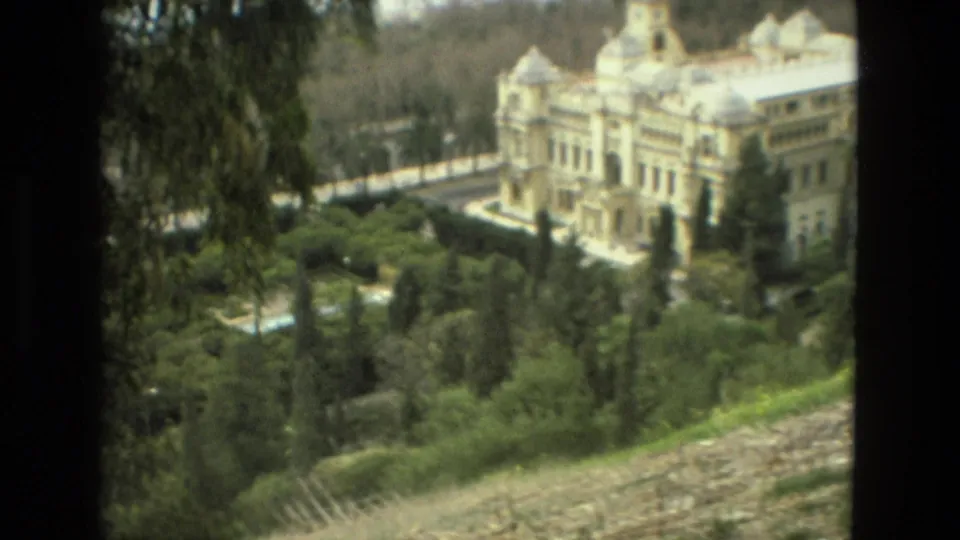 Granada travel footage frames a palace and surrounding garden from an elevated visitor viewpoint.