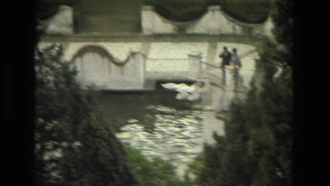 Granada garden footage shows distant visitors beside a water feature with swans and a bridge in view.