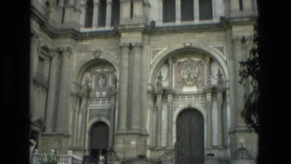 1978 Granada footage shows an ornate stone cathedral or church facade with arched doorways, carved panels, columns, and shadowed edges.