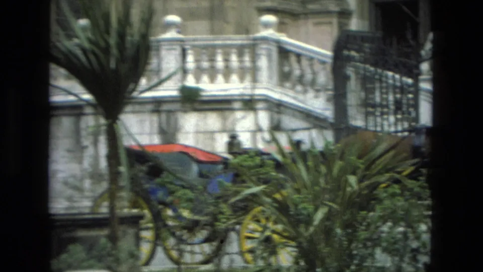 A horse-drawn carriage detail and greenery appear near the stone stairs and balustrade in Granada, Spain home-movie footage.
