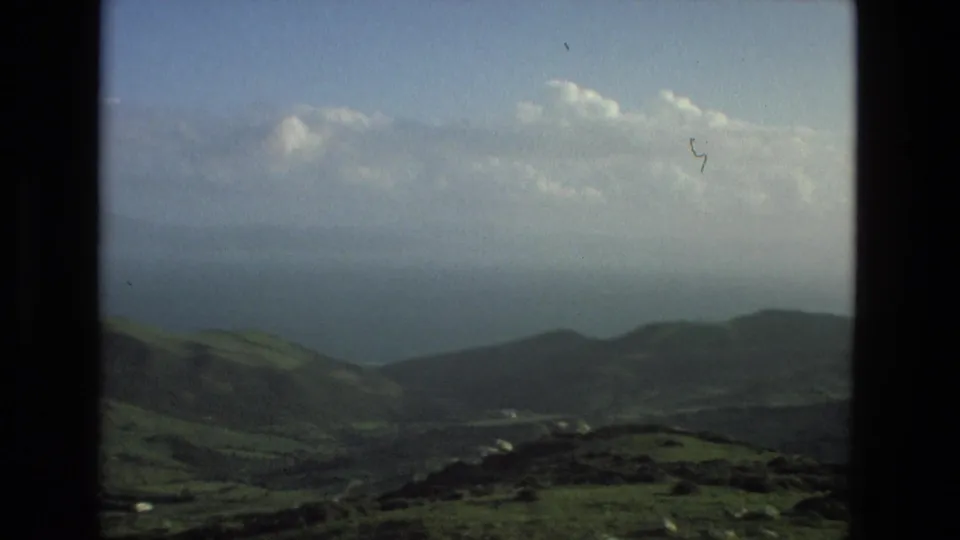 A broad 1978 Granada-area landscape view shows rolling green hills, distant haze, and a pale cloudy sky from an elevated viewpoint.