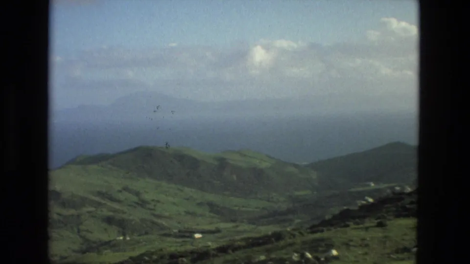 The final frame continues the Granada-area mountain panorama with layered green hills, valley floor details, and a hazy blue horizon.