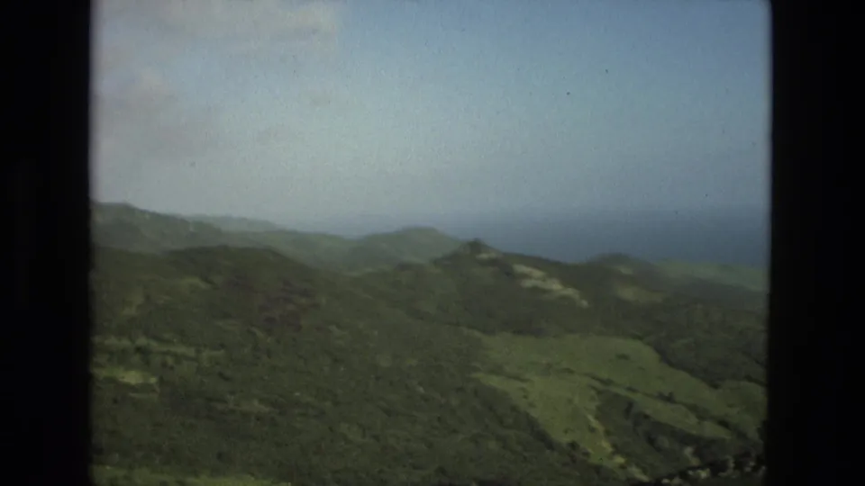 1978 8mm view of green hills in Granada, Spain, with distant ridges under a pale cloudy sky.