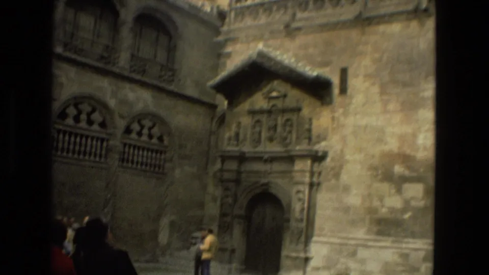 1978 Córdoba frame showing a small stone doorway, arched windows, and heavy weathered masonry from a visitor viewpoint.