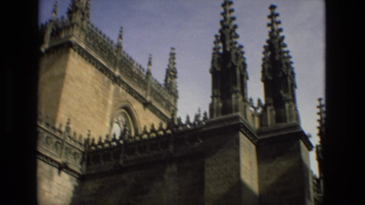 1978 Cordoba frame of a historic church exterior, showing warm stone walls, pointed spires, roofline ornament, and a clear sky.