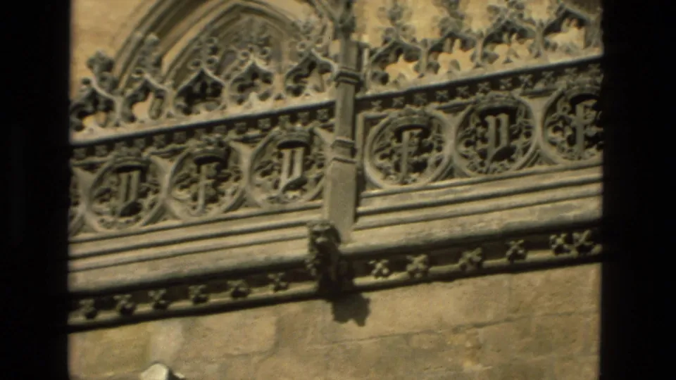 Córdoba, Spain facade detail on 8mm film, with repeated carved roundels and Gothic-style stone ornament.